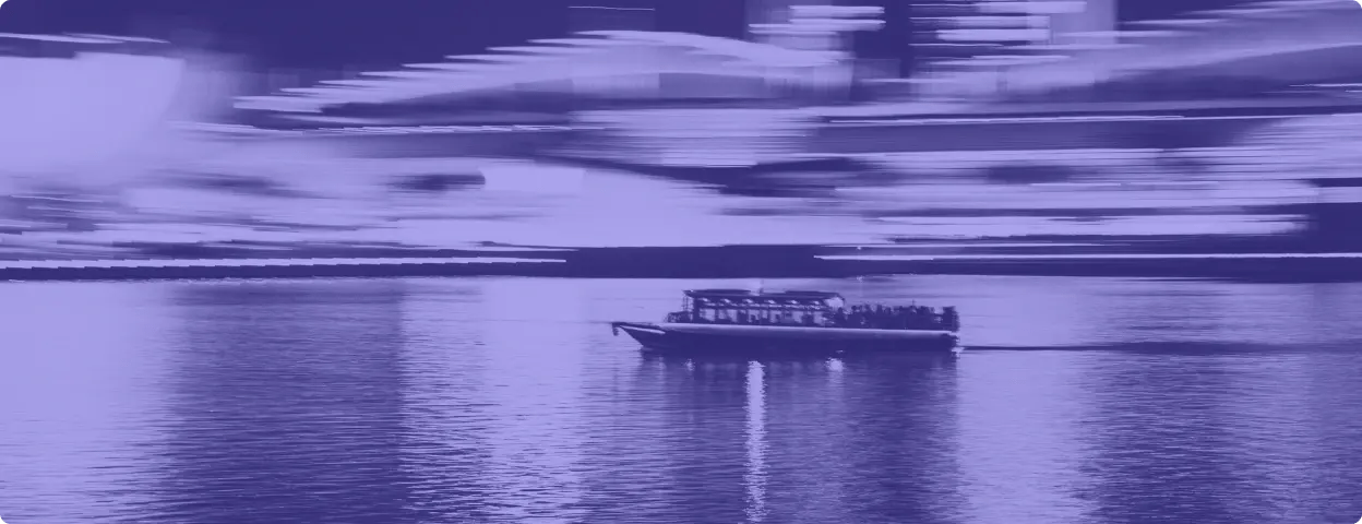 Photo of boat on water with city lights in background