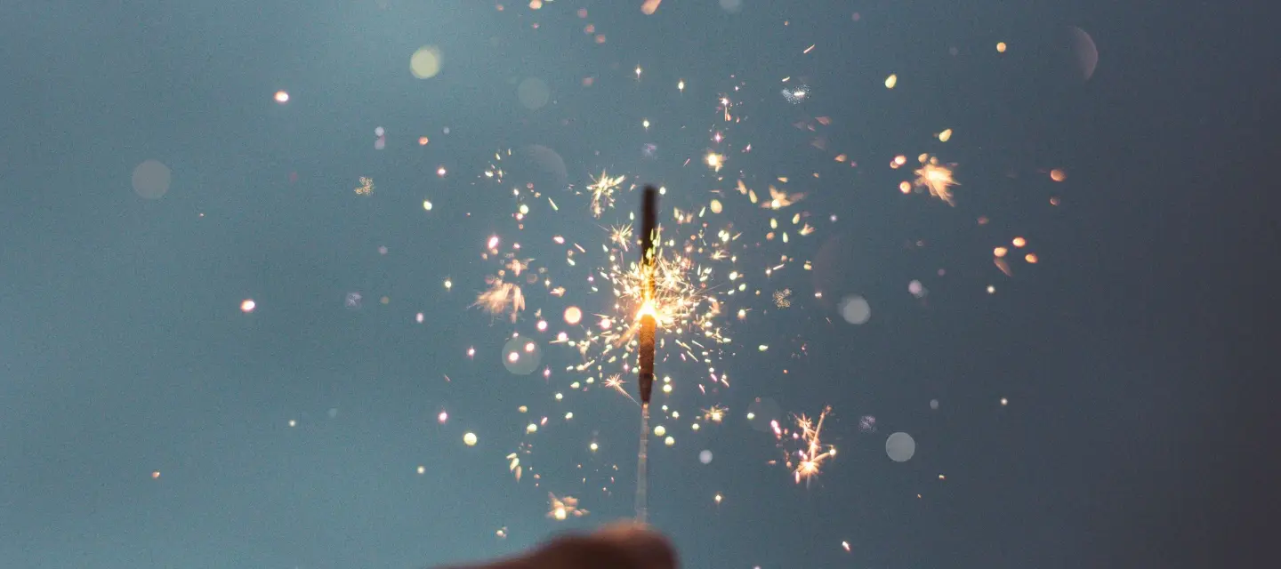 Photo of a hand holding a sparkler